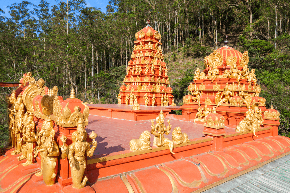Gilded statues and vibrant towers of a sacred temple on the Sri Lanka Ramayana Tour trail, surrounded by the lush green forests of Nuwara Eliya.
