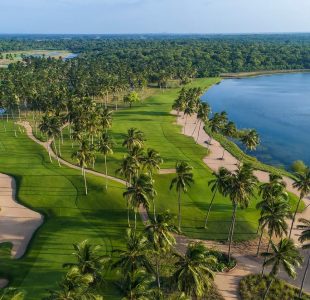 Tropical golf course aerial, with blue lake and green terrain. Explore Islandwyde’s pristine Golfing in Sri Lanka sri lanka holiday packages trips.