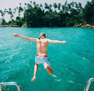 My Bucket List Adventures Person plunges into clear blue water from a boat. Experience Islandwyde’s best sri lanka holiday packages excursions