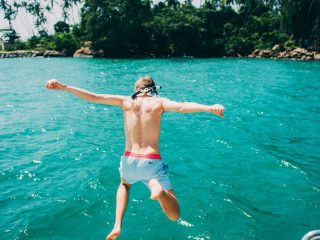 Person plunges into clear blue water from a boat. Experience Islandwyde’s best sri lanka holiday packages excursions